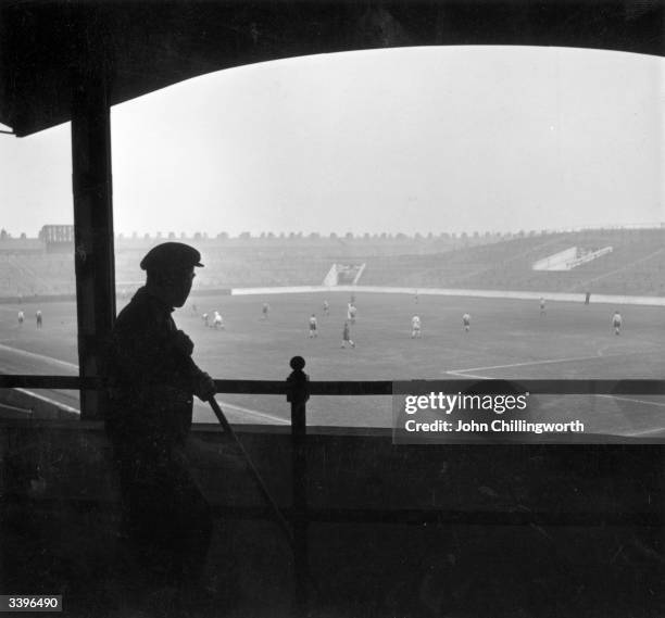 One of the ground staff watches the players of Manchester City Football Club during a training session at Maine Road. Original publication: Picture...