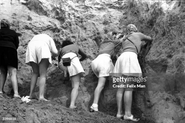 Tourists collecting sand in Alum Bay in the Isle of Wight. Original Publication: Picture Post - 241 - Hunters Of The Sand - pub. 1939