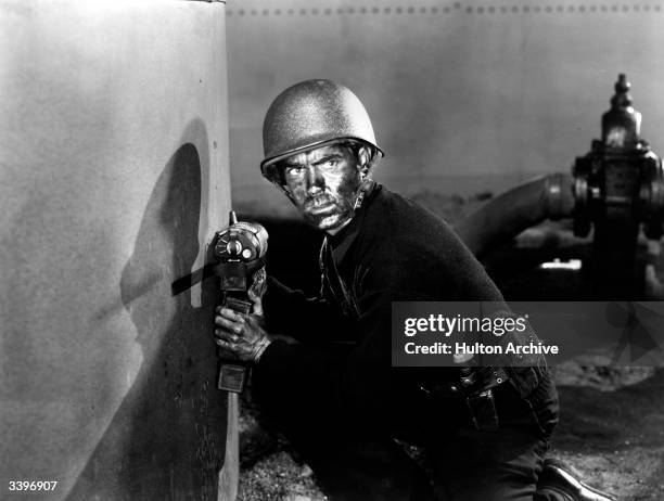 American actor Tyrone Power sets the bomb in the film 'Crash Dive', a wartime romance directed by Archie Mayo for 20th Century Fox.