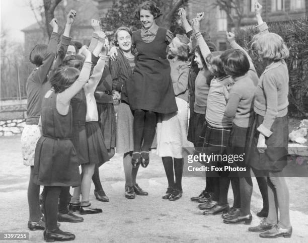 Year old Buxton schoolgirl Peggy Mycock is cheered by her friends for being chosen as the 1934 Festival Queen of Buxton, Derbyshire. She was selected...