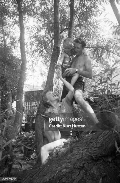 English actor John Mills, his wife playwright Mary Hayley-Bell and their daughter Juliet in the garden at their cottage in Denham village, England....