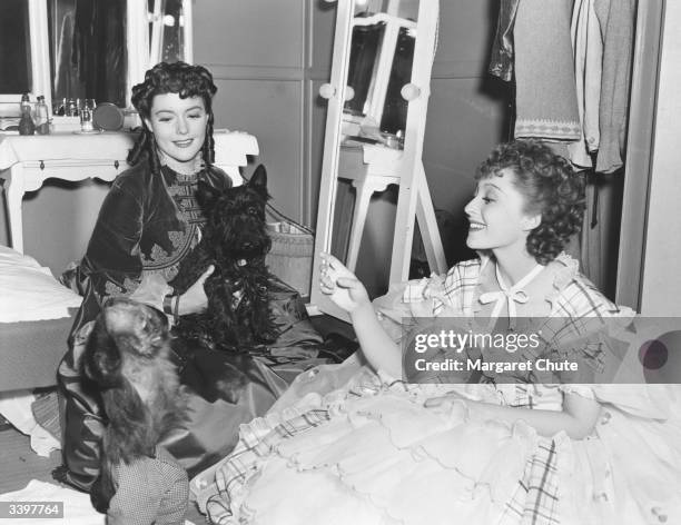 Actresses Barbara O'Neil and Luise Rainer in their dressing room with Miss O'Neil's pet dog and Professor Pepi, a ring-tailed monkey. All except the...