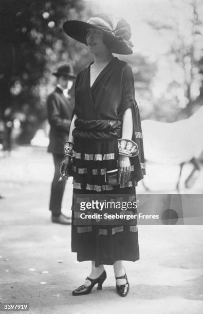 Model wearing an outfit designed by Madeleine Vionnet including a pair of ornate gloves.