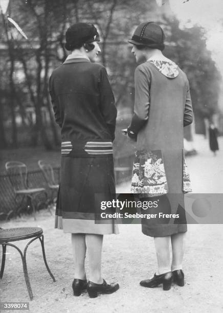 Two models wearing dresses with extra panels sewn on to them.