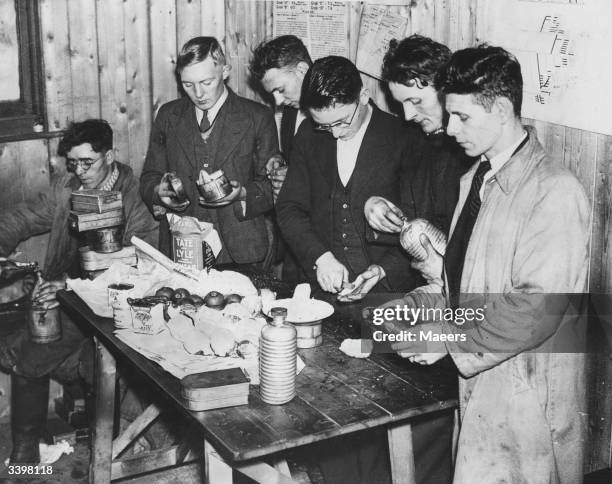 Some of the fourteen miners who have refused to leave the Olyn No.1 colliery, near Neath, South Wales, preparing some food. The cause of the trouble...