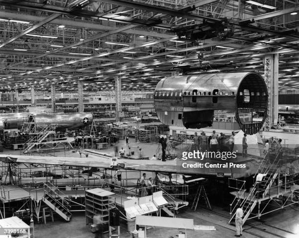 The centre fuselage section of Pan American Airlines first Boeing 707 Stratoliner jet being moved across the hangar to receive detail finishing.