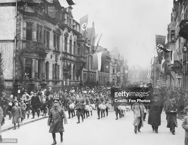 British troops arriving in Saar, Germany, as swastikas still fly from houses.