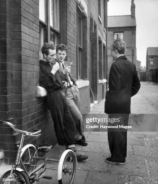 British boxer Frank Johnson sucking a lollipop with friends outside his house in Rusholme, Manchester, after his morning eight-mile run, during...