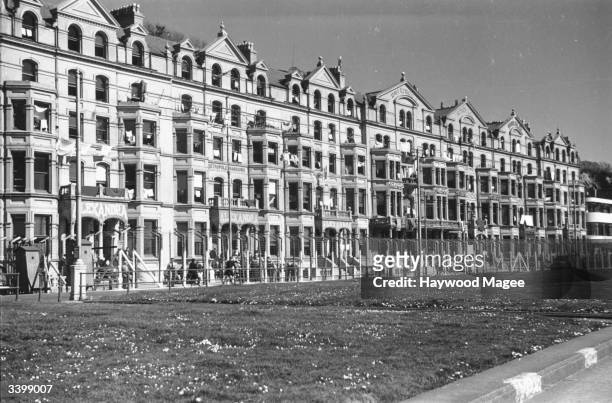 Houses and hotels lining the front at a seaside resort in the Isle of Man. Fenced behind barbed wire they are housing German nationals interned for...
