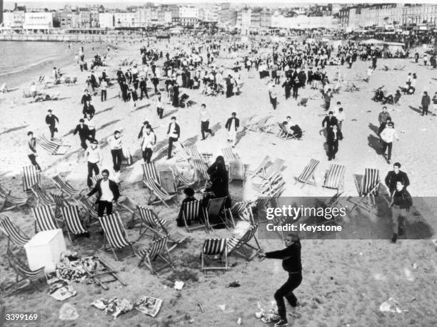 Mods invading the beach at Margate, Kent waving sticks and throwing bottles at retreating Rockers.