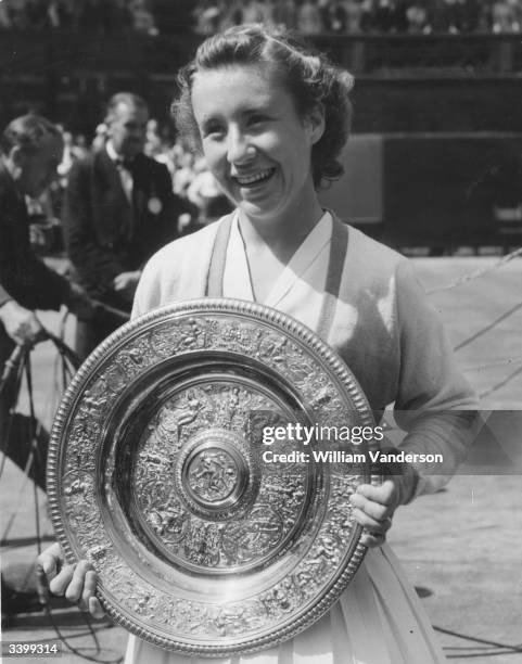 American tennis player Maureen Connolly holding the women's singles trophy after beating fellow American Louise Brough at the Wimbledon Lawn Tennis...