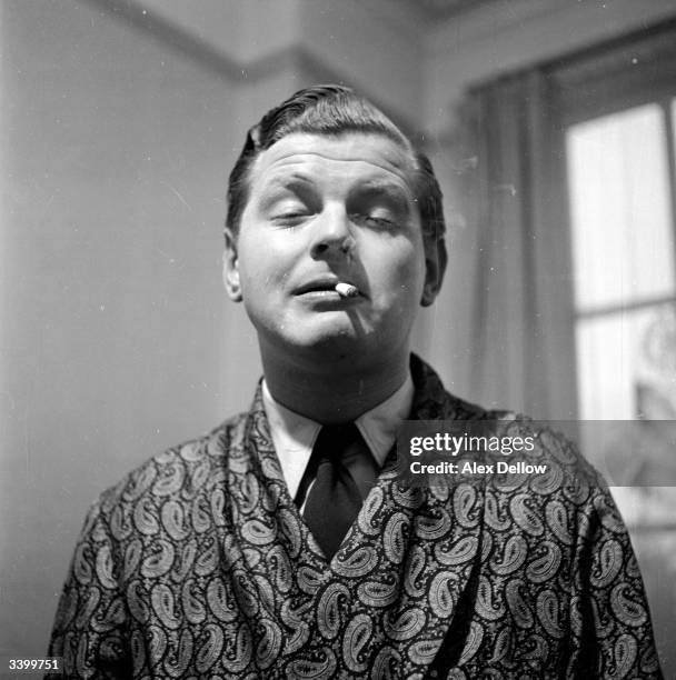 English comedian, Benny Hill originally Alfred Hawthorne Hill, smoking a cigarette. Original Publication: Picture Post - 6849 - The Queen's Champions...