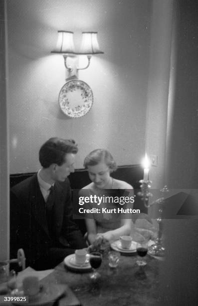 Young courting couple enjoy a candlelit dinner. Original Publication: Picture Post - 6513 - Two Nice People Fall In Love - pub. 1953