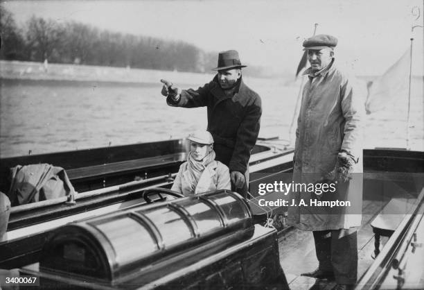 Ex world sculling champion Ted Phelps pointing out danger spots on the Thames to the Cambridge coxswain. His father 'Bossie' Phelps, right, is the...
