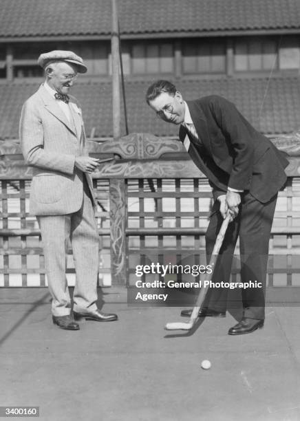 Willie MacFarland, US Open Golf champion with his millionaire caddy Jesse Winburn, practising on the roof of the McAlpin Hotel, New York for a...