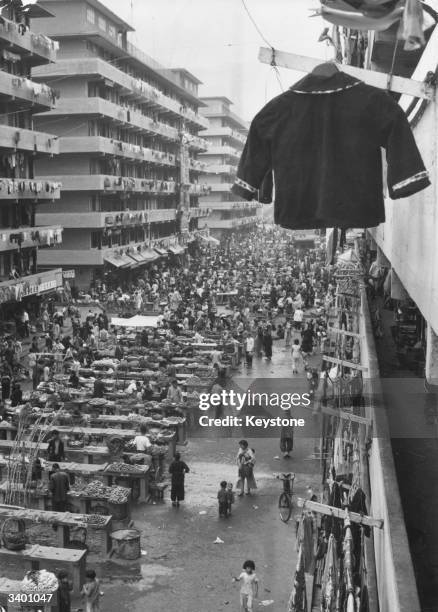 Market day in a street running between two large blocks of refugee flats at Causeway Bay, Hong Kong.