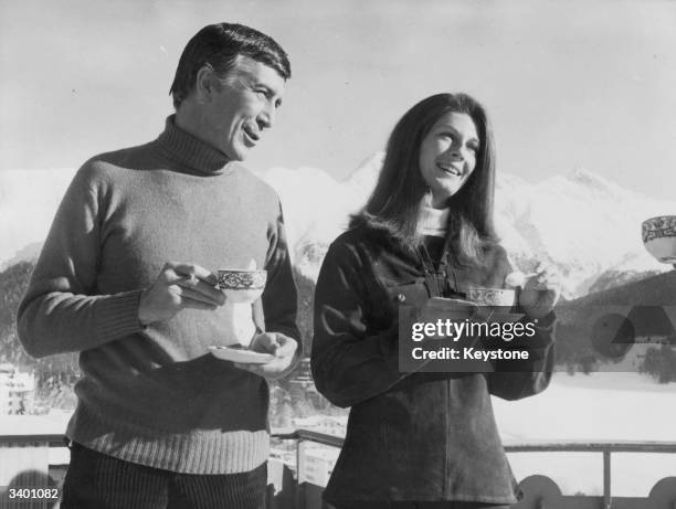 American film actor Patrick O'Neal and Baroness Fiona Thyssen take some tea on a balcony of the Palace Hotel, St Moritz during the filming of...