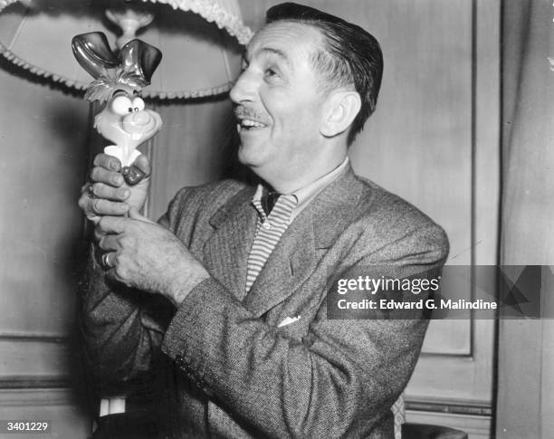 American animator and producer, Walt Disney , in London with one of the characters from his new film, 'Alice In Wonderland'.