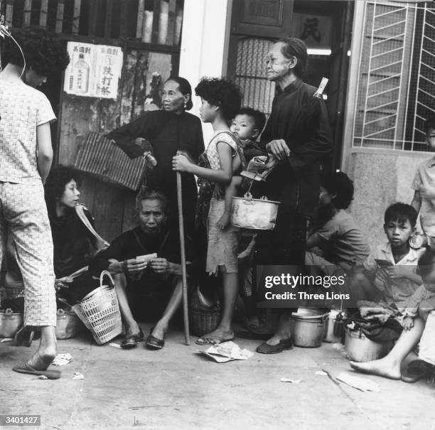 Chinese refugees whose homes have been devastated by a typhoon wait patiently for soup, being served on the streets of Hong Kong.