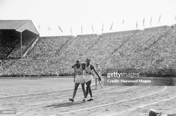 American sprinters Barney Ewell and Harrison Dillard walk arm in arm after the final of the 100 metres event at the 1948 London Olympics at Wembley...