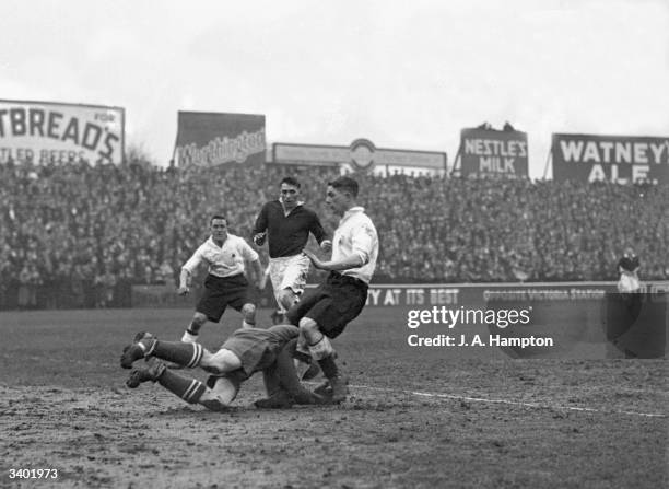 Millwall goalkeeper, Wilson, dives bravley to take the ball from the feet of Fulham's on-rushing Johnny Price, during a match between Fulham and...