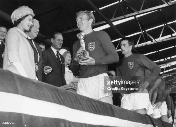 Queen Elizabeth II smiles after presenting England captain Bobby Moore with the Jules Rimet trophy, following England's 4-2 victory over West Germany...