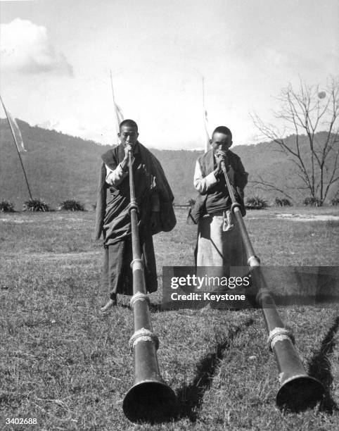 Tibetan monks playing long trumpets at the Festival of Kanchenjunga in Tibet.