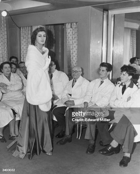 New Zealand born fashion model Fiona Campbell-Walter models 'Gloriana', a white mink stole, for members of staff at the rehearsals for a fashion show...