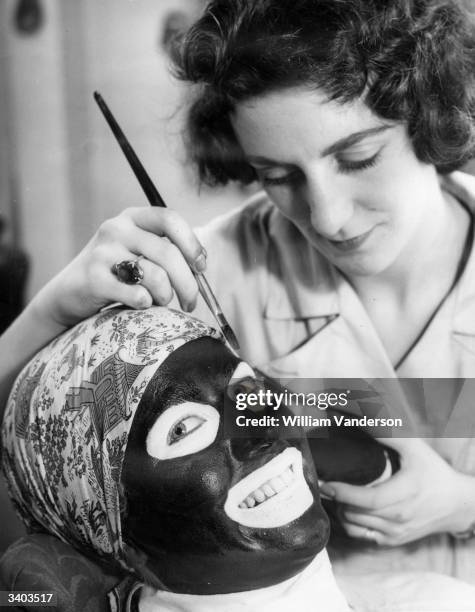 Ann Hely painting the face of her colleague Susan Shepherd at the BBC television make-up school at Ealing Studios.