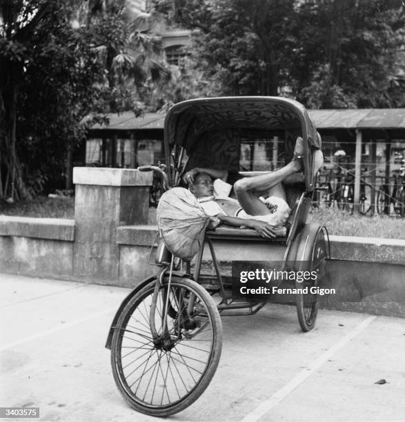 Pedicab driver napping in his vehicle between fares in Taipei, Taiwan.