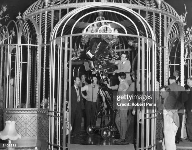 Director of photography Douglas Slocombe and his crew setting up their equipment inside a cage in the Cage d'Or nightclub whilst shooting the Ealing...