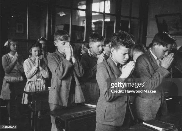 Children praying at their desks in class at Walsgrave Colliery School near Coventry. Original Publication: Picture Post - 9109 - Overcrowded Schools...