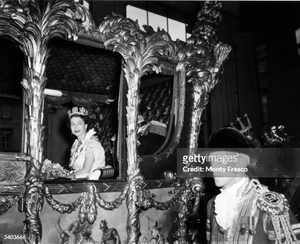 Queen Elizabeth II looking out from her carriage en route to Westminster Abbey for her Coronation ceremony.