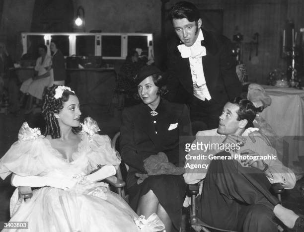 Joan Crawford , Barbara Stanwyck, Henry Fonda and James Stewart during filming of 'The Gorgeous Hussy', based on the love life of Peggy O'Neal, the...