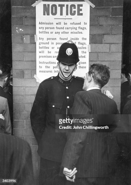 Policemen gives advice to a fan at the local derby football match between Glasgow Rangers and Celtic at the Ibrox stadium in Glasgow. Large crowds...