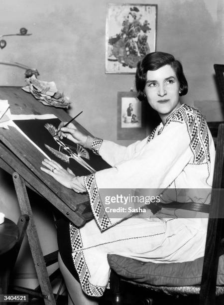 Dress designer Ada Peacock at work at her drawing board on a