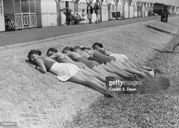 Row of young women sunbathing on the beach at Shoeburyness.