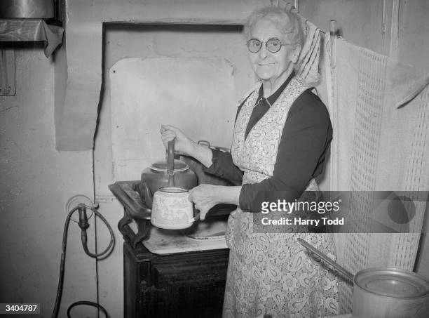 Year old Mrs Clara Stockbridge of Rainham, Kent who is the Christmas Queen of the local Derby and Joan club makes herself a cup of tea at her home.