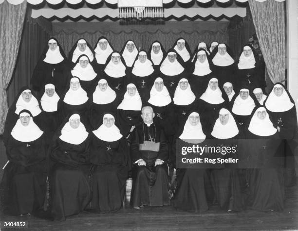 Formal portrait of The Sisters Of Mercy, with the Archbishop of Westminster William Godfrey, taken to commemorate their centenary