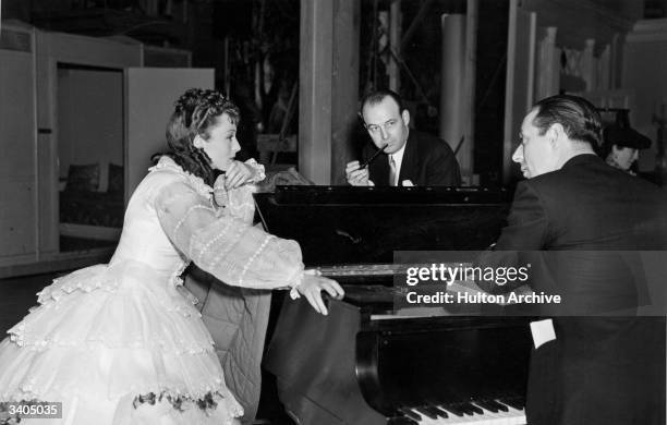 Austrian actress Luise Rainer discusses a waltz scene in 'The Toy Wife' with Edward Ward of the MGM music department and Richard Thorpe the film's...