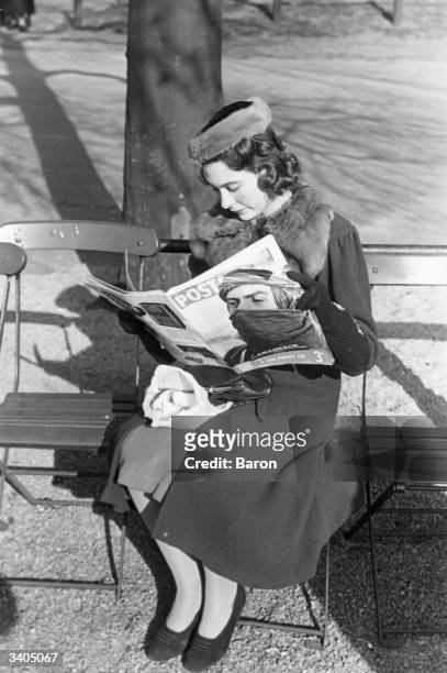 British woman reading a copy of Picture Post with a portrait of French soldier, General Berthomet in Tuareg dress on the cover.