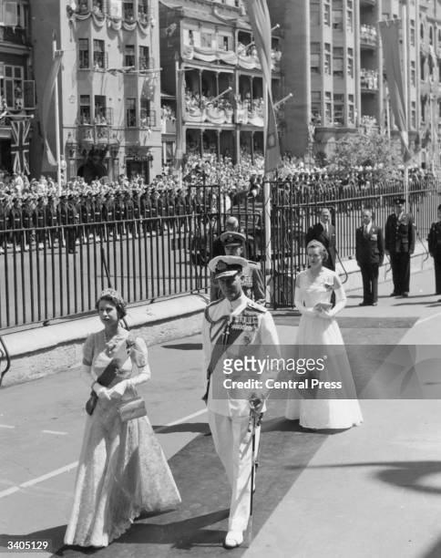 Queen Elizabeth II, in a lace gown, and Prince Philip, Duke of Edinburgh, wearing a white naval uniform, arriving for the opening of parliament in...