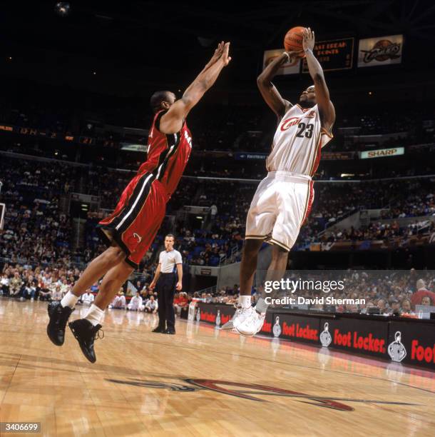 LeBron James of the Cleveland Cavaliers makes a jump shot against Caron Butler of the Miami Heat at Gund Arena on April 10, 2004 in Cleveland, Ohio....