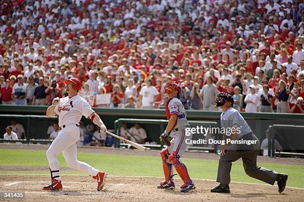 Mark McGwire of the St. Louis Cardinals hits his 70th home run of the season as catcher Michael Barrett of the Montreal Expos and umpire Rich Rieker...