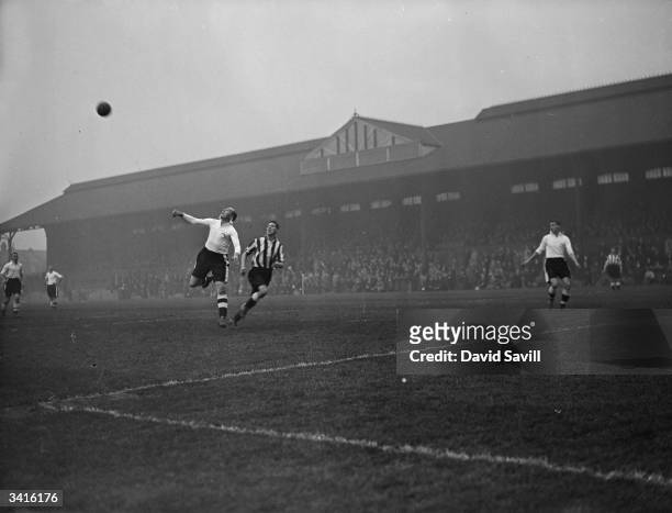 Fulham's centre-half beats Smith, the Newcastle United centre-forward, in a duel for the ball during a match at Fulham's Craven Cottage ground.