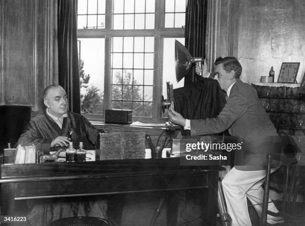 Photographer Alex 'Sasha' Stewart sets up his camera for a portrait of English crime novelist and screenwriter Richard Horatio Edgar Wallace at the...