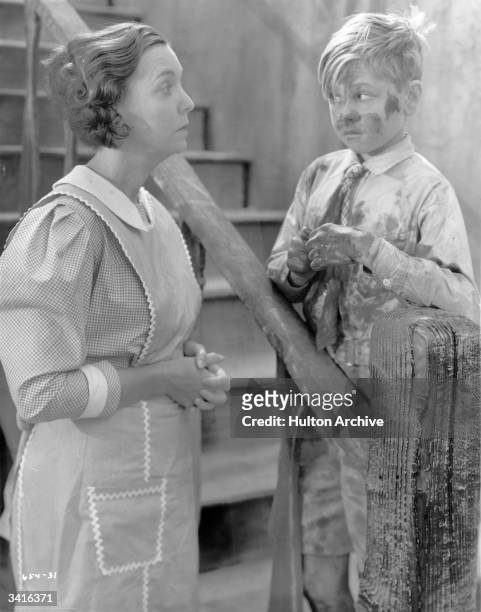 Guilty looking child star Mickey Rooney encountering ZaSu Pitts while covered in mud in a scene from the film 'Love Birds'.