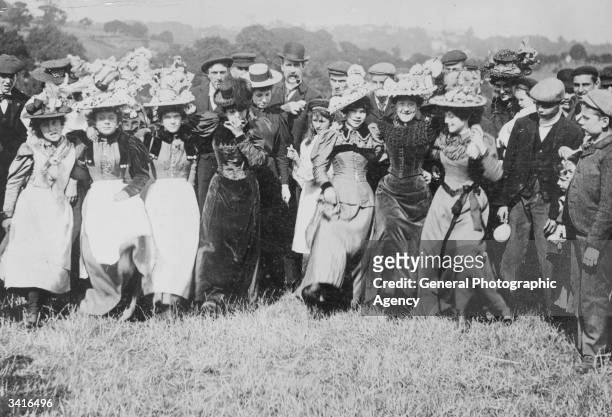 Holiday crowd, complete with Easter bonnets, dancing on London's Hampstead Heath during the Bank Holiday break from work.