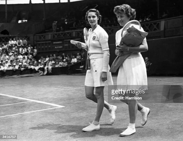 British tennis player Kay Menzies and her American opponent Miss D Bundy walking onto the court for their match at the Wimbledon Lawn Tennis...