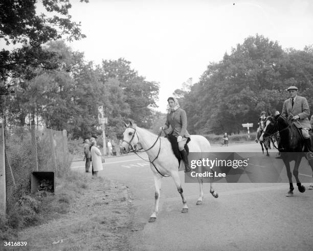 Queen Elizabeth II on her grey horse, 'Surprise', followed by Lt-Col Dawnay leading members of her house party to the entrance of Ascot racecourse,...